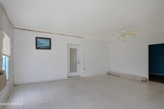 2116 George Dr, Opelousas, LA 70570 - empty room with brick wall, ceiling fan, and tile patterned floors