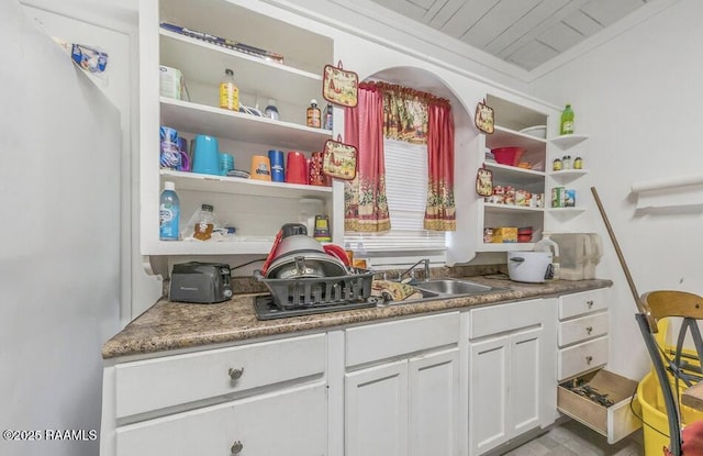 1110 Louisiana Ave, Lafayette, LA 70501 - kitchen featuring open shelves, a sink, white cabinetry, and freestanding refrigerator