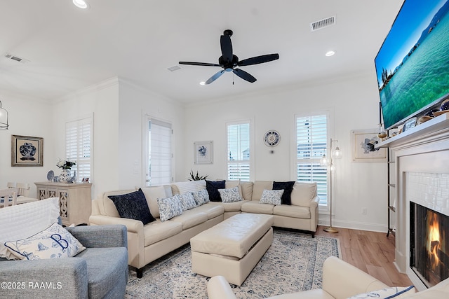 337 Bozeman Trl, Scott, LA 70583 - living area featuring light wood finished floors, ceiling fan, a tile fireplace, recessed lighting, and crown molding