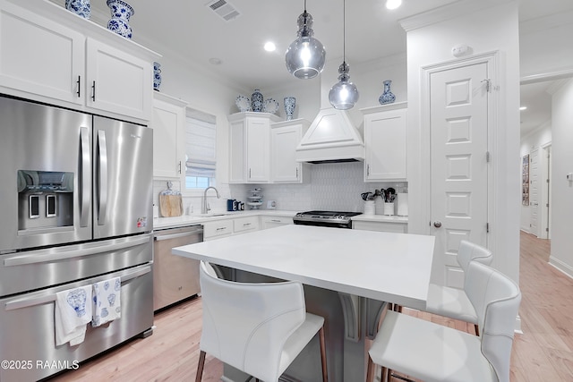 337 Bozeman Trl, Scott, LA 70583 - kitchen with appliances with stainless steel finishes, crown molding, a breakfast bar area, backsplash, and white cabinets