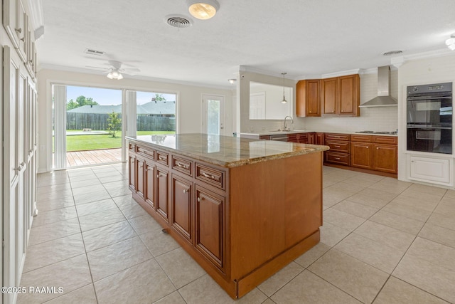 4119 Pleasant Dr, Lake Charles, LA 70605 - kitchen featuring wall chimney exhaust hood, crown molding, brown cabinets, plenty of natural light, and gas cooktop