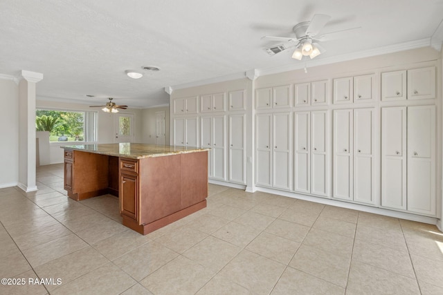 4119 Pleasant Dr, Lake Charles, LA 70605 - kitchen with a ceiling fan, brown cabinets, ornamental molding, light tile patterned floors, and light stone countertops