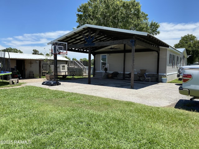 119 Opus Ln, Lafayette, LA 70506 - view of green lawn with a carport, a trampoline, a patio area, and driveway