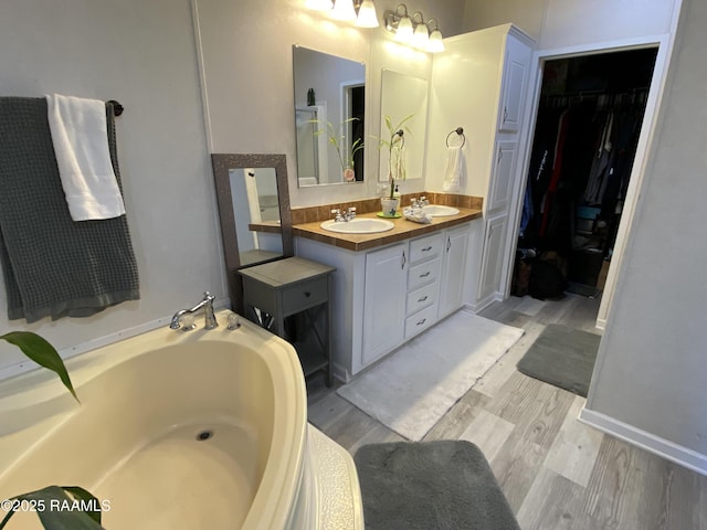 119 Opus Ln, Lafayette, LA 70506 - full bath with wood finished floors, a bath, double vanity, and a spacious closet