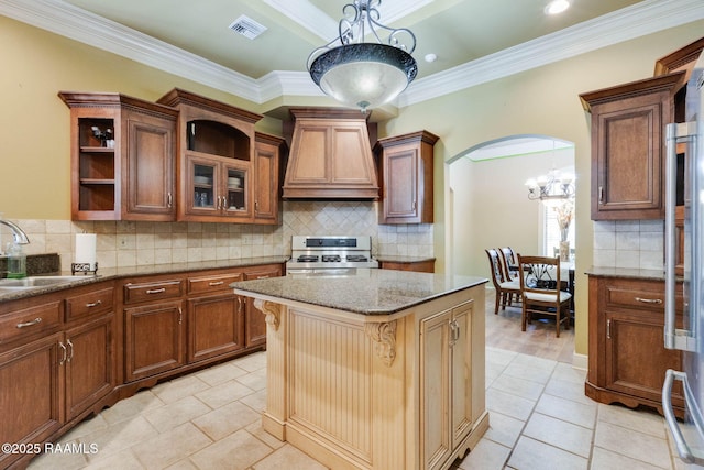 605 Terrell Ct, New Iberia, LA 70563 - kitchen with gas range, custom range hood, a sink, backsplash, and light stone countertops