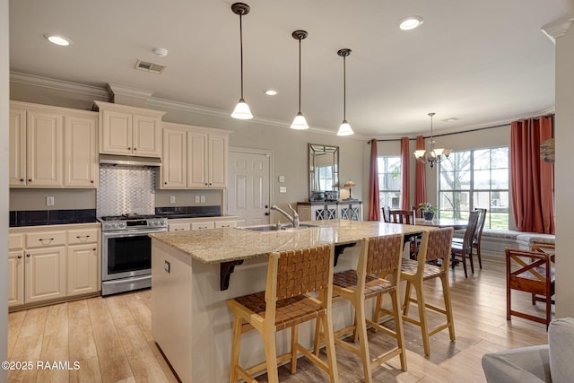 209 E Vincent St, Maurice, LA 70555 - kitchen featuring gas stove, a sink, under cabinet range hood, a breakfast bar, and crown molding