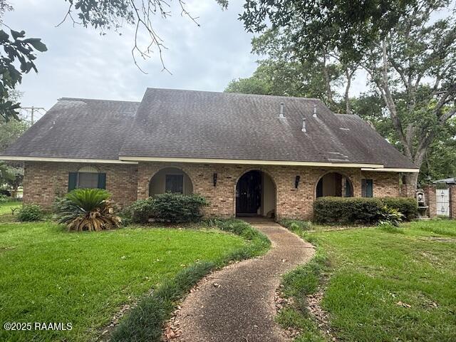 401 Great Slave Ave, Eunice, LA 70535 - view of front of home featuring a front lawn, brick siding, and a shingled roof