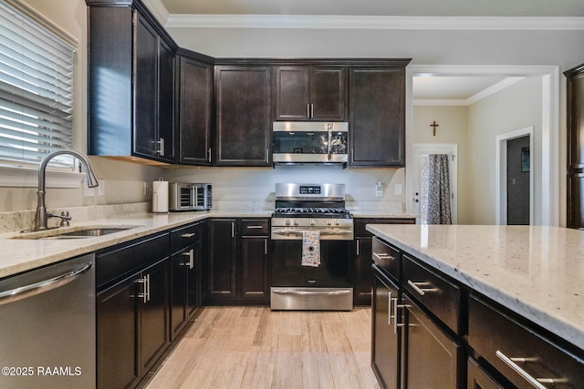 111 Rose Of Sharon Ln, Lafayette, LA 70508 - kitchen featuring appliances with stainless steel finishes, a sink, light wood-style floors, light stone counters, and ornamental molding