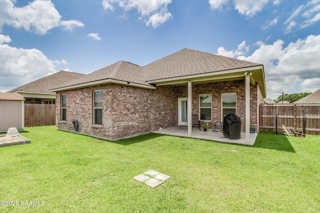111 Rose Of Sharon Ln, Lafayette, LA 70508 - back of property featuring roof with shingles, a patio area, brick siding, and an outbuilding