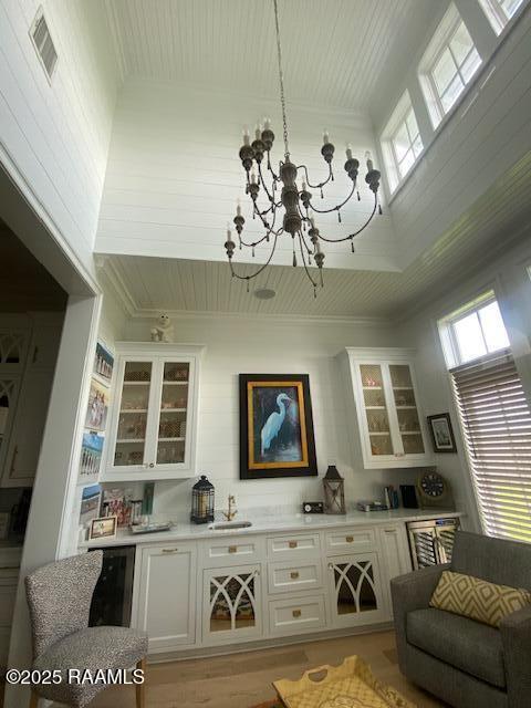 207 Bronze Palm Way, Youngsville, LA 70592 - indoor dry bar with healthy amount of natural light, a chandelier, ornamental molding, and light wood-style flooring
