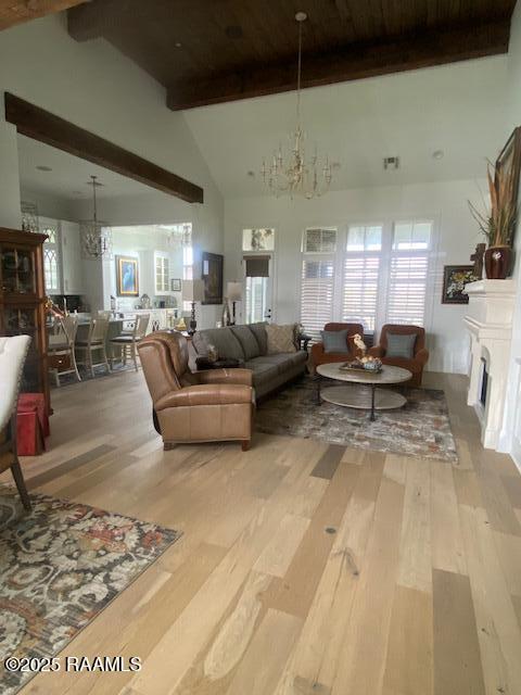 207 Bronze Palm Way, Youngsville, LA 70592 - living area with a chandelier, beam ceiling, light wood-style flooring, high vaulted ceiling, and plenty of natural light