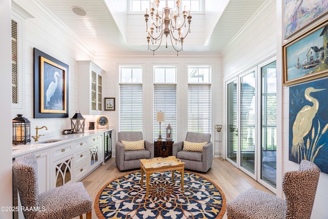 207 Bronze Palm Way, Youngsville, LA 70592 - living area with beverage cooler, light wood-style floors, a chandelier, and crown molding