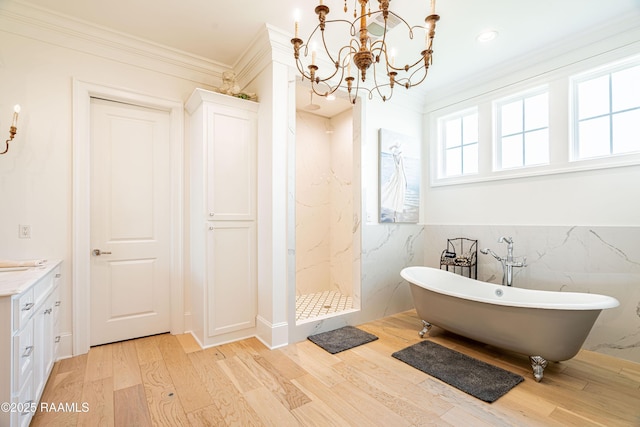 207 Bronze Palm Way, Youngsville, LA 70592 - full bathroom featuring wood finished floors, ornamental molding, a freestanding tub, a chandelier, and a marble finish shower