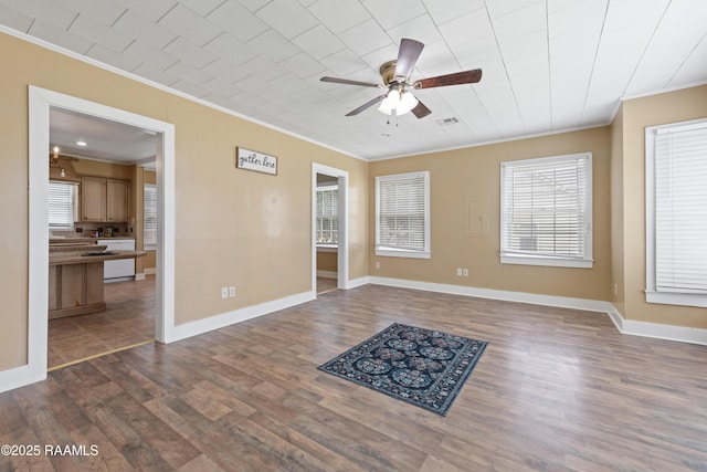 206 N Fernand St, Delcambre, LA 70528 - empty room with crown molding, ceiling fan, dark wood finished floors, and healthy amount of natural light