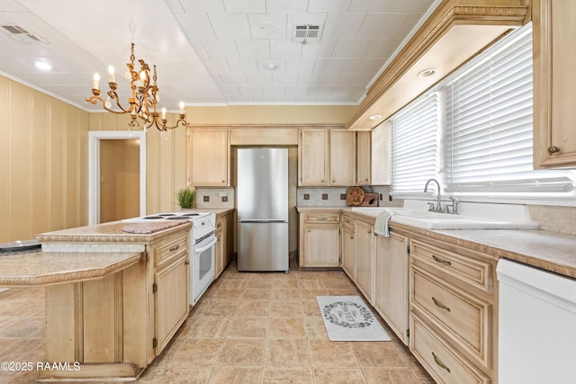 206 N Fernand St, Delcambre, LA 70528 - kitchen featuring white appliances, light brown cabinetry, ornamental molding, a chandelier, and a peninsula