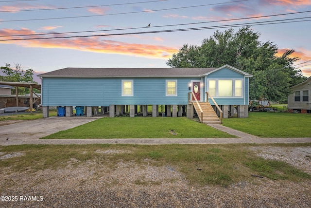206 N Fernand St, Delcambre, LA 70528 - view of front of property with a carport, a yard, driveway, and a shingled roof