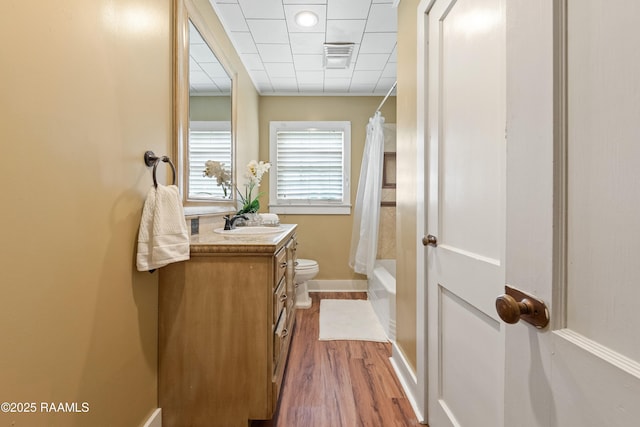 206 N Fernand St, Delcambre, LA 70528 - full bath with vanity, toilet, wood finished floors, shower / bath combo with shower curtain, and baseboards