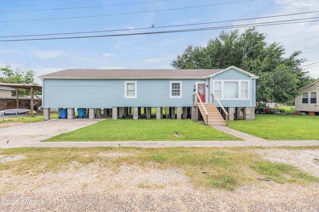 206 N Fernand St, Delcambre, LA 70528 - view of front of property with a carport, roof with shingles, a front yard, and concrete driveway