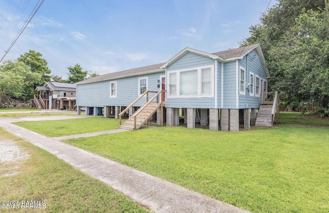 206 N Fernand St, Delcambre, LA 70528 - view of front of house featuring stairway and a front yard