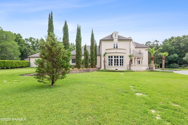 12425 N Marcus Rd, Abbeville, LA 70510 - view of front facade featuring a balcony, stucco siding, and a front lawn