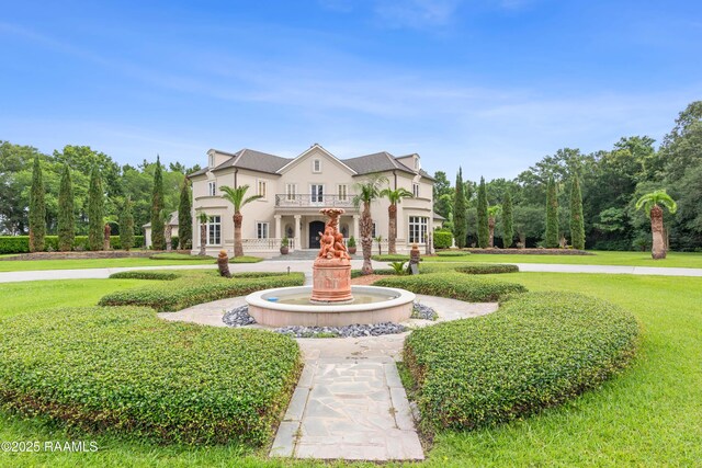 12425 N Marcus Rd, Abbeville, LA 70510 - view of front of home with stucco siding, a front lawn, and a balcony
