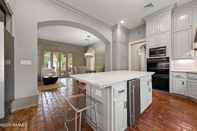 12425 N Marcus Rd, Abbeville, LA 70510 - kitchen with arched walkways, brick flooring, open floor plan, ornamental molding, and beverage cooler