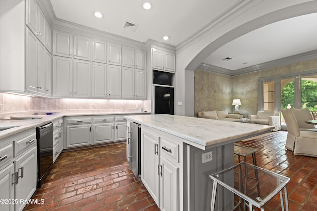 12425 N Marcus Rd, Abbeville, LA 70510 - kitchen featuring dishwasher, crown molding, a breakfast bar, white cabinets, and arched walkways