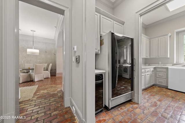 12425 N Marcus Rd, Abbeville, LA 70510 - kitchen featuring freestanding refrigerator, brick flooring, light countertops, ornamental molding, and white cabinetry