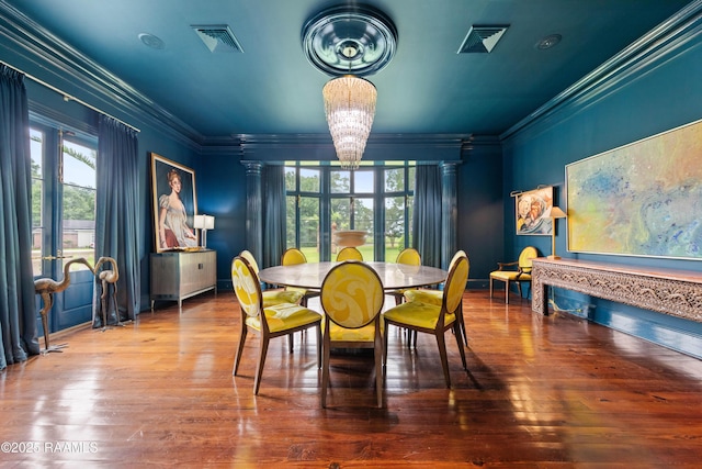 12425 N Marcus Rd, Abbeville, LA 70510 - dining room with ornamental molding, a chandelier, healthy amount of natural light, wood-type flooring, and decorative columns