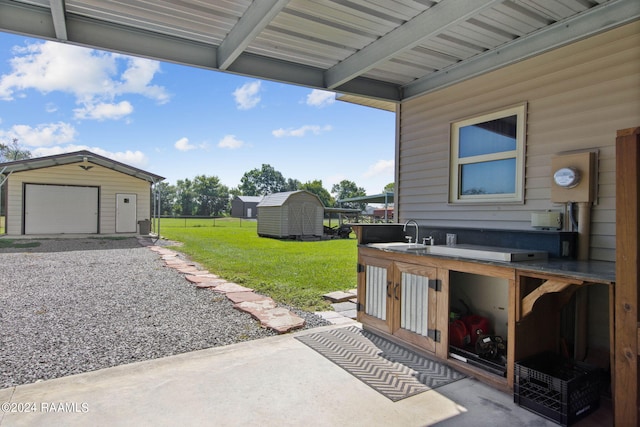 1037 Joe Kidder Rd, Arnaudville, LA 70512 - view of patio featuring a detached garage, a sink, and driveway