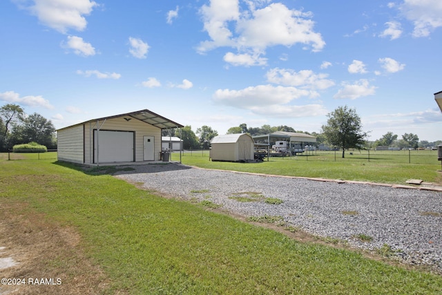 1037 Joe Kidder Rd, Arnaudville, LA 70512 - garage with driveway, a detached garage, and a storage unit