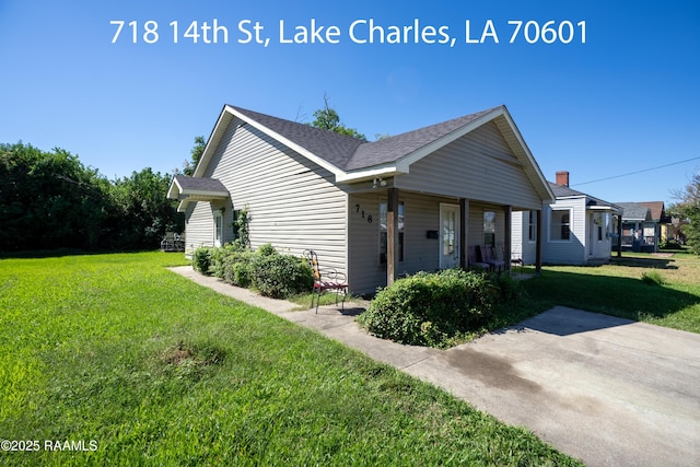 718 14th St, Lake Charles, LA 70601 - view of side of property featuring a yard, a shingled roof, and covered porch
