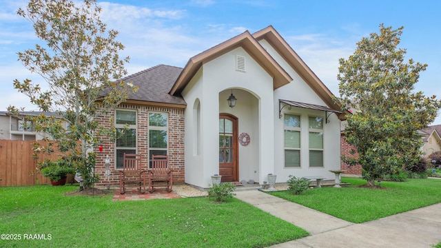 111 Grand Pointe Blvd, Lafayette, LA 70508 - view of front of home featuring stucco siding, a shingled roof, and brick siding