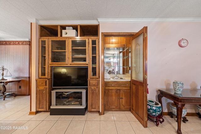 510 Monarch Dr, Lafayette, LA 70506 - kitchen featuring brown cabinetry, crown molding, a sink, light countertops, and light tile patterned floors