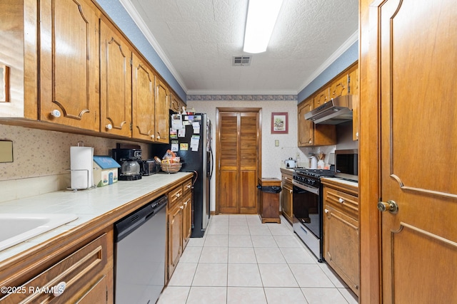 510 Monarch Dr, Lafayette, LA 70506 - kitchen featuring appliances with stainless steel finishes, tile countertops, under cabinet range hood, brown cabinetry, and crown molding