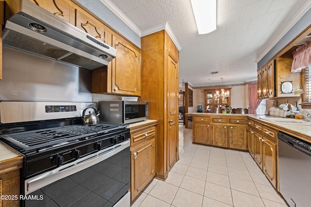 510 Monarch Dr, Lafayette, LA 70506 - kitchen featuring stainless steel appliances, under cabinet range hood, a chandelier, a sink, and light tile patterned flooring