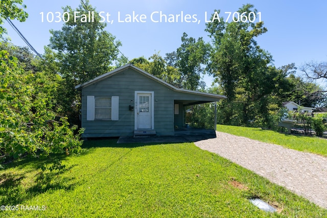 702 Sycamore St, Lake Charles, LA 70601 - bungalow-style home with driveway, a front yard, and an attached carport