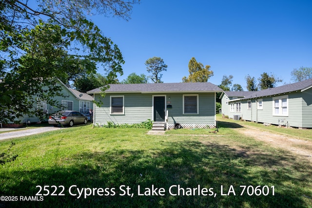 702 Sycamore St, Lake Charles, LA 70601 - view of front facade featuring entry steps, a front lawn, and central AC unit