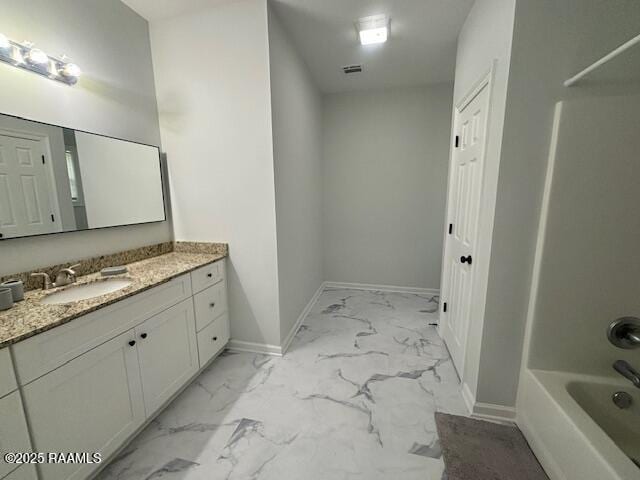 214 Dufilho Rd, Opelousas, LA 70570 - bathroom with vanity, marble look tiles, baseboards, and shower / bath combination