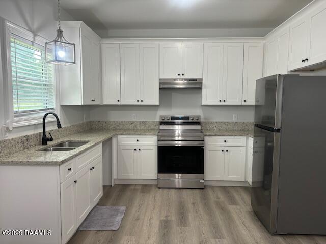 214 Dufilho Rd, Opelousas, LA 70570 - kitchen with appliances with stainless steel finishes, a sink, under cabinet range hood, white cabinetry, and light wood finished floors