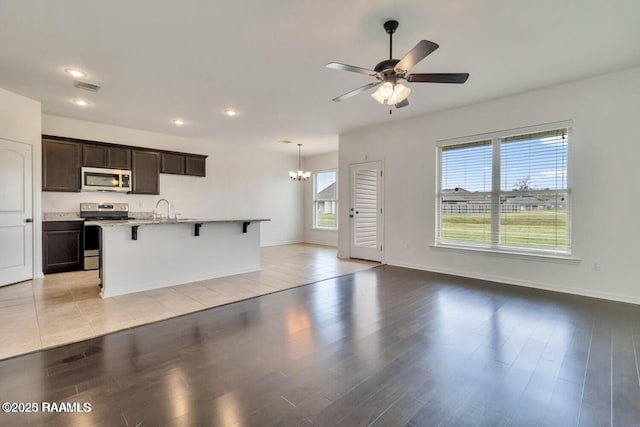 406 Elwick Dr, Lafayette, LA 70507 - unfurnished living room with a chandelier, a ceiling fan, recessed lighting, a sink, and light wood-style floors