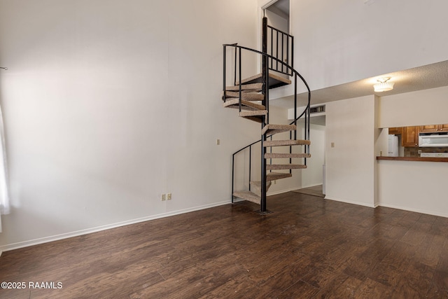 300 Lozes Ave Apt 1503, Lafayette, LA 70508 - unfurnished living room with wood finished floors, stairway, baseboards, and a towering ceiling