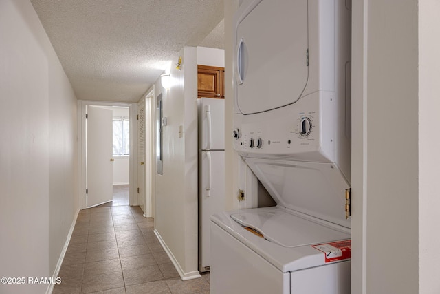 300 Lozes Ave Apt 1503, Lafayette, LA 70508 - washroom featuring stacked washer / drying machine, light tile patterned floors, baseboards, and a textured ceiling