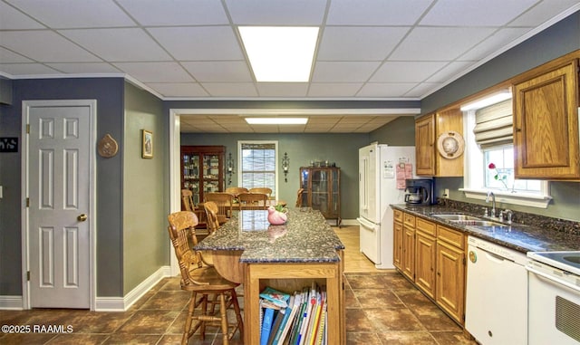 151 Hickory St, Port Barre, LA 70577 - kitchen featuring white appliances, a sink, brown cabinetry, a drop ceiling, and dark stone counters