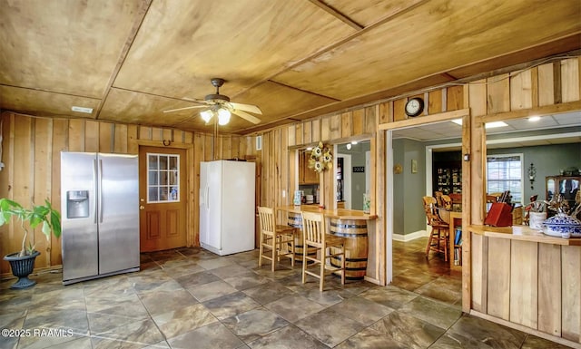 151 Hickory St, Port Barre, LA 70577 - kitchen featuring stainless steel fridge, freestanding refrigerator, a ceiling fan, and wooden walls