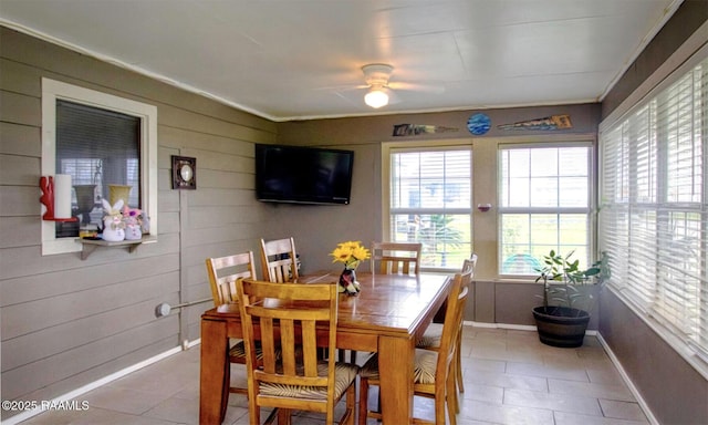 151 Hickory St, Port Barre, LA 70577 - dining area with a ceiling fan, tile patterned flooring, wood walls, baseboards, and crown molding