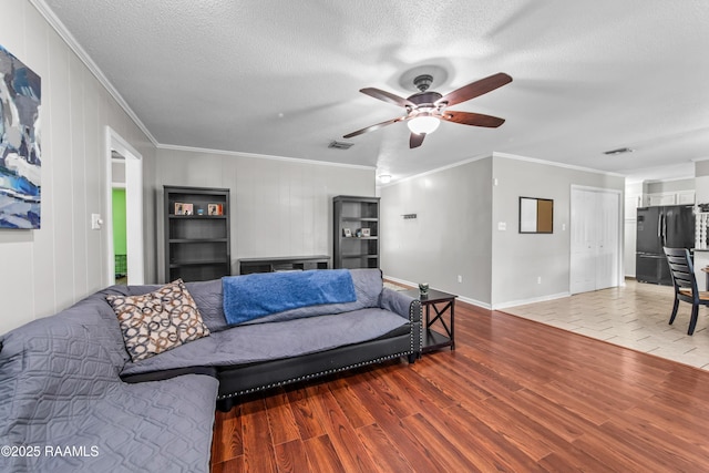 315 Creswell Ave, Scott, LA 70583 - living room featuring a ceiling fan, wood finished floors, crown molding, baseboards, and a textured ceiling