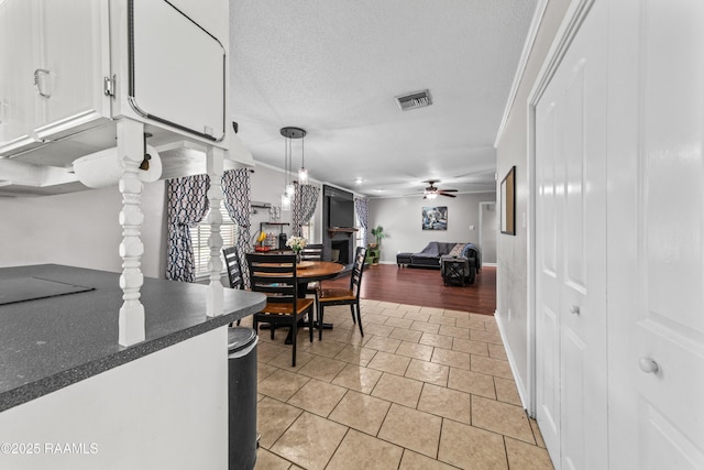 315 Creswell Ave, Scott, LA 70583 - kitchen with light tile patterned floors, dark countertops, white cabinetry, ceiling fan, and pendant lighting