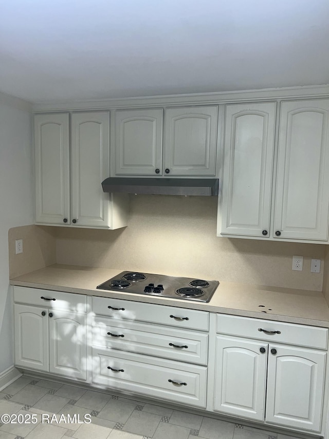 421 Lippi Blvd, Lafayette, LA 70508 - kitchen with electric stovetop, light countertops, under cabinet range hood, and white cabinets