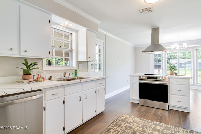 1010 Domingue St, Breaux Bridge, LA 70517 - kitchen with stainless steel appliances, island range hood, dark wood-style floors, ornamental molding, and white cabinetry
